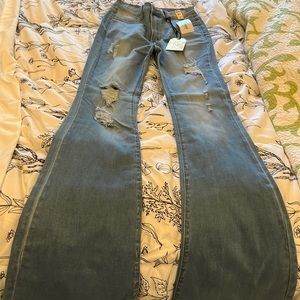 High rise skinny flared out jeans at the bottom .